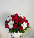Arreglo en base de cerámica con rosas rojas y orquídeas