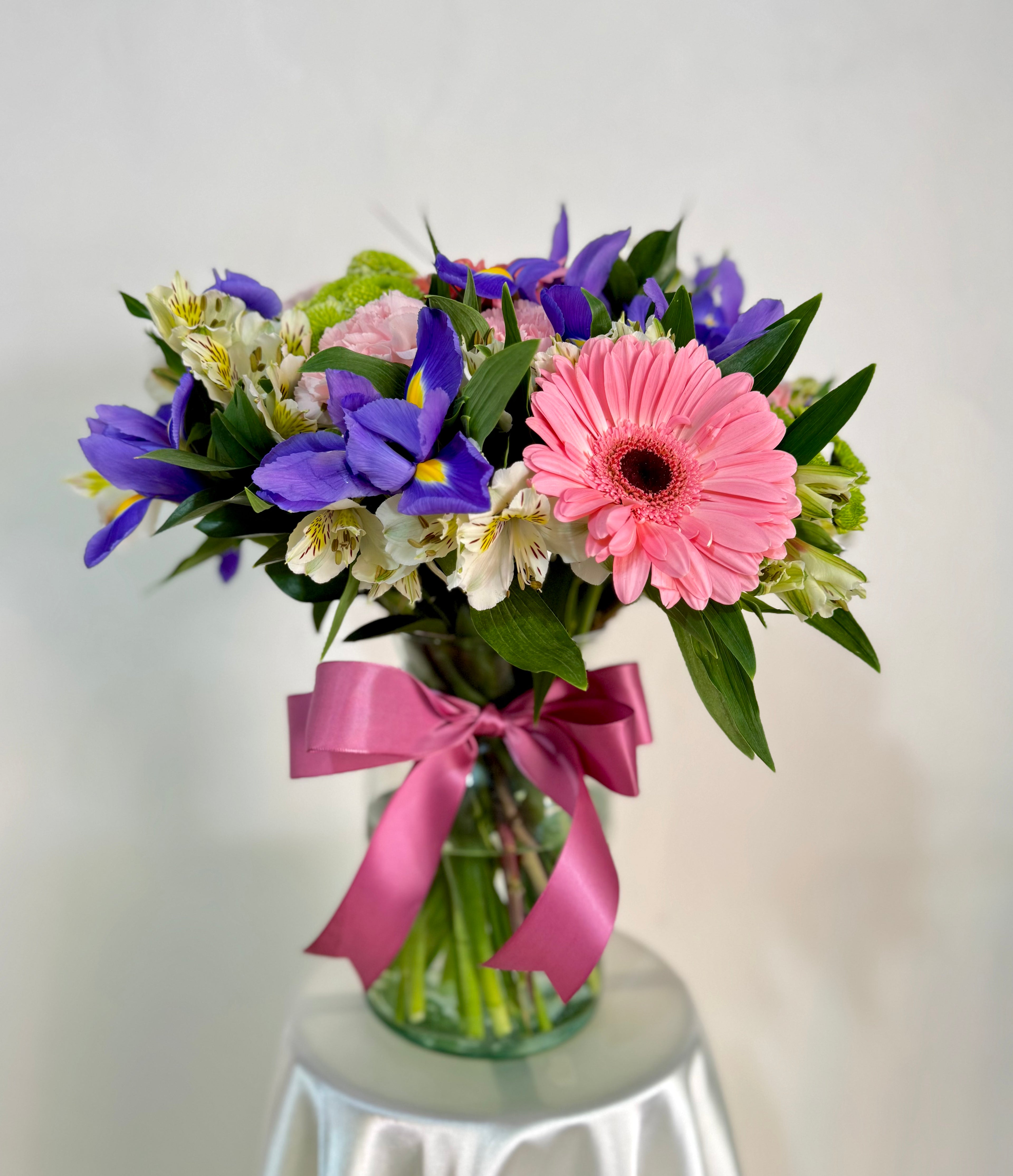 Florero con iris, rosas y gerberas